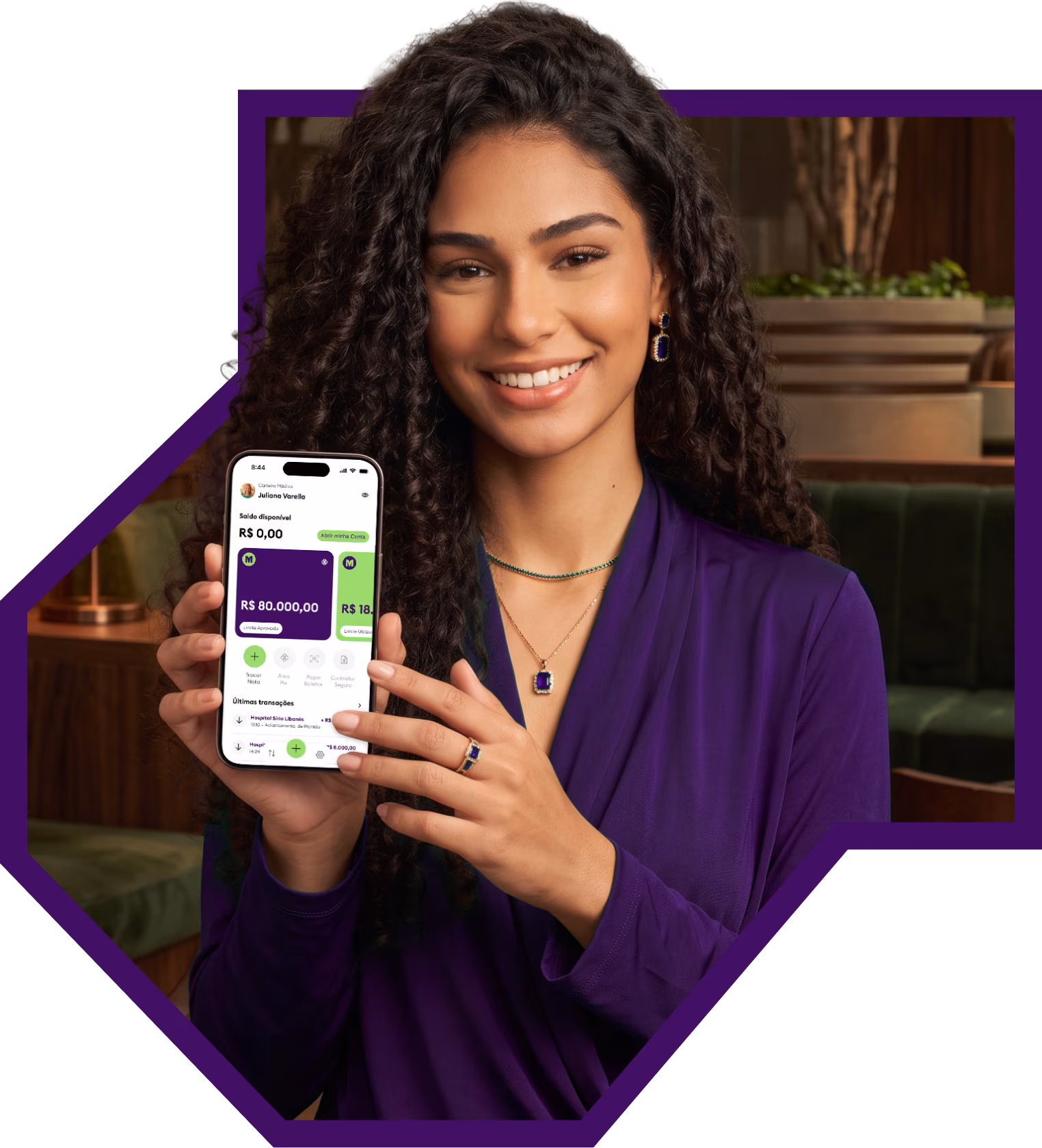 Médica sorrindo segurando o celular com o app da Medcred aberto